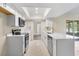 Bright kitchen featuring white cabinets, stainless steel appliances, quartz countertops and tile floor at 6509 Pine Meadows Dr, Spring Hill, FL 34606