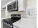 Kitchen with stainless steel appliances, white countertops, and abundant natural light at 6509 Pine Meadows Dr, Spring Hill, FL 34606