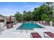 Community pool with lounge chairs and umbrellas, surrounded by lush greenery at 6509 Pine Meadows Dr, Spring Hill, FL 34606