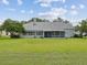 Spacious backyard with lush lawn, trees, and a screened-in lanai at 6545 North Lake Dr, Zephyrhills, FL 33542