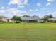 Spacious backyard with lush lawn, trees, and a screened-in lanai at 6545 North Lake Dr, Zephyrhills, FL 33542