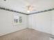 This bedroom has neutral carpet, a ceiling fan, and natural light from the window at 6545 North Lake Dr, Zephyrhills, FL 33542
