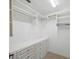 Walk-in closet with custom shelves, drawers, and carpeting for storage at 6545 North Lake Dr, Zephyrhills, FL 33542