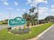 Silver Oaks deed restricted community sign with manicured landscaping and mature trees under a sunny blue sky at 6545 North Lake Dr, Zephyrhills, FL 33542
