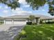 Charming one-story home boasts a well-manicured lawn and a spacious three-car garage at 6545 North Lake Dr, Zephyrhills, FL 33542