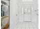 Bright foyer showcasing white tile flooring and the decorative front door at 6545 North Lake Dr, Zephyrhills, FL 33542