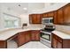 Well-equipped kitchen featuring stainless steel appliances, dark wood cabinets, and a window offering natural light at 6545 North Lake Dr, Zephyrhills, FL 33542
