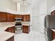 Well-lit kitchen with stainless steel appliances and dark wood cabinets provides ample counter space at 6545 North Lake Dr, Zephyrhills, FL 33542