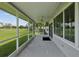 Enclosed lanai with screens, ceiling fan, and view of a grassy lawn at 6545 North Lake Dr, Zephyrhills, FL 33542