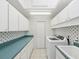 Bright laundry room featuring a washer, dryer, and teal countertop with ample storage at 6545 North Lake Dr, Zephyrhills, FL 33542