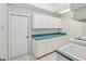 Spacious laundry room with teal countertops and ample cabinet space at 6545 North Lake Dr, Zephyrhills, FL 33542