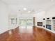 Bright living room featuring hardwood floors, fireplace, and sliding glass doors to the lanai at 6545 North Lake Dr, Zephyrhills, FL 33542