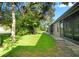 Home exterior featuring a peaceful backyard with mature trees and manicured lawn at 6590 Brambleleaf Dr, Spring Hill, FL 34606