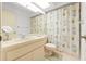 Well-lit bathroom with a vanity, toilet, and shower/tub combo with a skylight at 6590 Brambleleaf Dr, Spring Hill, FL 34606