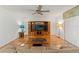 Bright living room features a ceiling fan, hardwood floors, and entertainment center at 6590 Brambleleaf Dr, Spring Hill, FL 34606