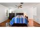 Comfortable bedroom with wood floors, ceiling fan, two windows, and a modern bed frame at 6590 Brambleleaf Dr, Spring Hill, FL 34606
