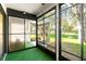 Enclosed porch with green carpet and sliding glass doors for views of the green yard at 6590 Brambleleaf Dr, Spring Hill, FL 34606