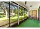 Relaxing screened porch featuring a seating area and views of the lush green yard at 6590 Brambleleaf Dr, Spring Hill, FL 34606