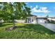 Charming single-story home with a well-manicured lawn and a tree in the front yard at 7118 Cherry Laurel Dr, Port Richey, FL 34668
