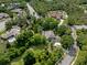 Expansive aerial shot showcasing the home's setting amid dense trees, green lawn, and nearby residences in a suburban area at 7268 Crystal Spring Run, Weeki Wachee, FL 34607
