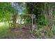 A charming backyard featuring a wooden swing, lush foliage, and a serene ambiance at 7268 Crystal Spring Run, Weeki Wachee, FL 34607