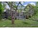 Backyard view showcasing mature trees, manicured lawn, and private pool area at 7268 Crystal Spring Run, Weeki Wachee, FL 34607