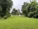 Expansive grassy backyard featuring mature trees and a fountain at 7268 Crystal Spring Run, Weeki Wachee, FL 34607