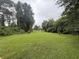 Large backyard features well maintained lawn with mature trees and fountain feature at 7268 Crystal Spring Run, Weeki Wachee, FL 34607
