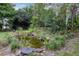 A serene backyard pond surrounded by lush greenery and natural rock formations, creating a peaceful oasis at 7268 Crystal Spring Run, Weeki Wachee, FL 34607