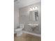 Bright bathroom with a toilet, sink, vanity mirror, and light fixture at 7268 Crystal Spring Run, Weeki Wachee, FL 34607