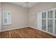 Bright bedroom featuring shutter doors, hardwood floors, and neutral paint at 7268 Crystal Spring Run, Weeki Wachee, FL 34607