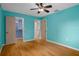 Bedroom with wood floors, ceiling fan, walk-in closet, and interior door at 7268 Crystal Spring Run, Weeki Wachee, FL 34607