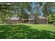 Charming front exterior view of a brick home with a covered porch, manicured lawn, and mature trees providing shade at 7268 Crystal Spring Run, Weeki Wachee, FL 34607