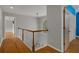 Upstairs hallway with wood floors, staircase, and interior doors at 7268 Crystal Spring Run, Weeki Wachee, FL 34607