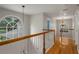 Hallway with hardwood floors and staircase with white banister at 7268 Crystal Spring Run, Weeki Wachee, FL 34607