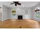 Bright living room with hardwood floors, fireplace, built-in shelving, and a ceiling fan at 7268 Crystal Spring Run, Weeki Wachee, FL 34607