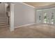 Bright living room featuring tile floors, a staircase, and glass doors leading outside at 7268 Crystal Spring Run, Weeki Wachee, FL 34607