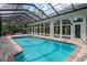 Indoor swimming pool with screened ceiling and brick patio with hot tub at 7268 Crystal Spring Run, Weeki Wachee, FL 34607