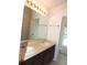 Bathroom featuring dual sinks, a large mirror, and neutral finishes at 7650 Red Mill Cir, New Port Richey, FL 34653