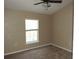 Neutral bedroom featuring ceiling fan, window, and carpeted floor at 7650 Red Mill Cir, New Port Richey, FL 34653