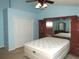 Light-filled main bedroom with ceiling fan and view of mirrored cabinet at 7650 Red Mill Cir, New Port Richey, FL 34653