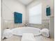Bright bathroom featuring a soaking tub, ceramic tile, and a window letting in natural light at 8199 Nordica Rd, Weeki Wachee, FL 34613