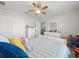 Bright bedroom featuring a ceiling fan, white walls, closet, dresser and colorful ' toys at 8199 Nordica Rd, Weeki Wachee, FL 34613