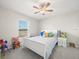 Cozy bedroom featuring a ceiling fan, white walls, and a window overlooking the neighborhood at 8199 Nordica Rd, Weeki Wachee, FL 34613