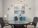 Inviting dining area featuring a round glass table with wicker chairs, complemented by floral decor and wall art at 8199 Nordica Rd, Weeki Wachee, FL 34613