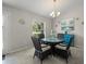 Cozy dining room features a glass-top table, four wicker chairs, and an elegant chandelier at 8199 Nordica Rd, Weeki Wachee, FL 34613