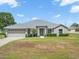 Charming single-story home with a well-maintained lawn and a two-car garage and decorative shrubs along the front of the house at 8199 Nordica Rd, Weeki Wachee, FL 34613