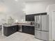 Open concept kitchen featuring stainless steel appliances, dark cabinets, and neutral countertops at 8199 Nordica Rd, Weeki Wachee, FL 34613