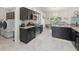 Open kitchen with stainless steel appliances, dark cabinetry, and adjacent laundry room at 8199 Nordica Rd, Weeki Wachee, FL 34613