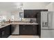 Kitchen featuring a stainless steel refrigerator, dark cabinets, a breakfast bar, and a view into adjacent living areas at 8199 Nordica Rd, Weeki Wachee, FL 34613